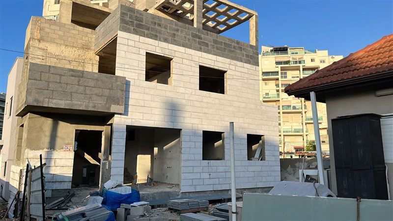 חיפוי אבן בחזית של בניין בשלבי בנייה
