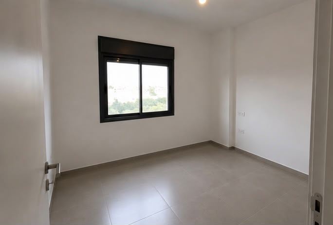 חדר גמור עם ריצוף בהיר וחלון אלומיניום שחור