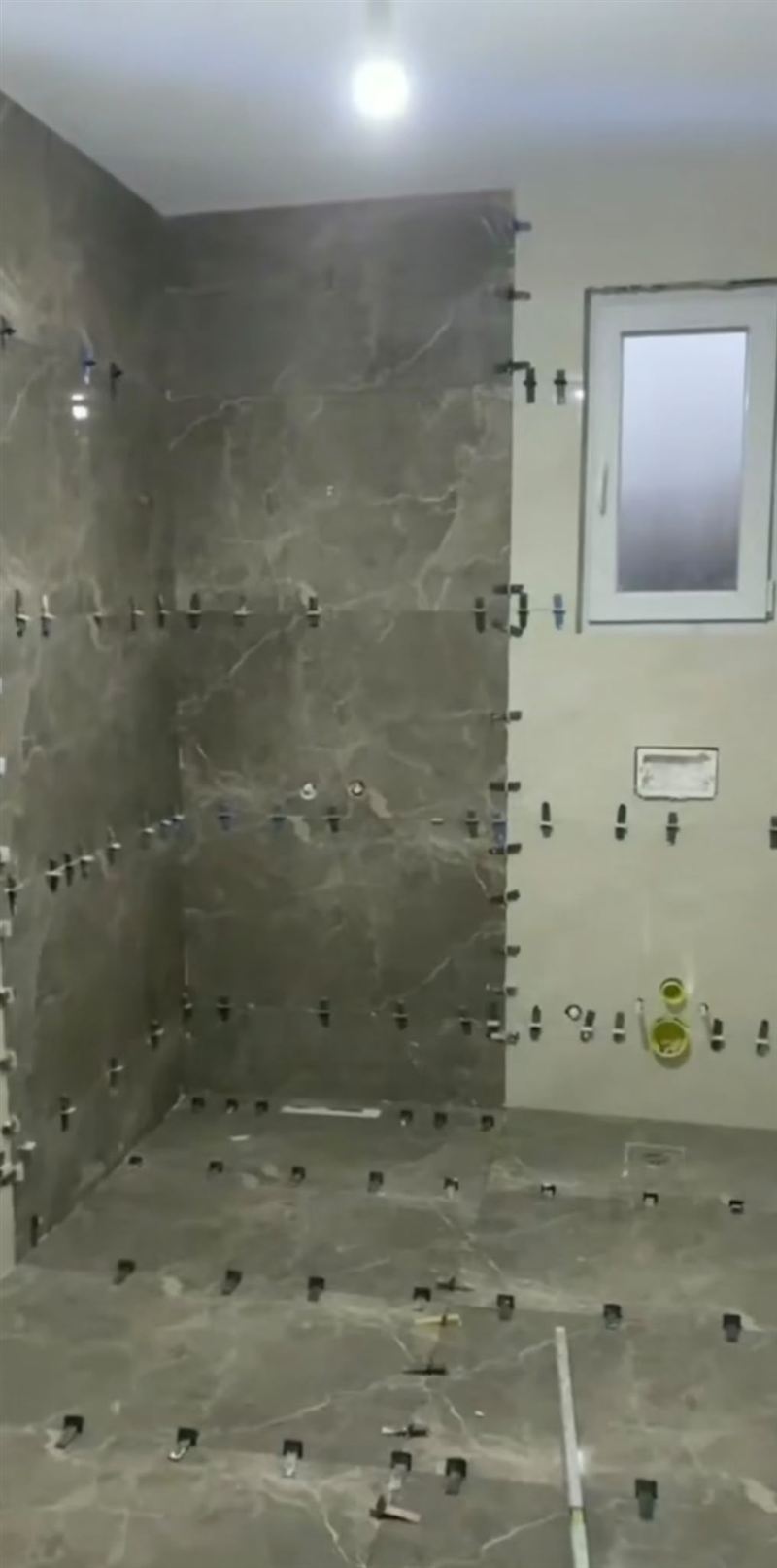 חיפוי וריצוף שיש אפור בחדר רחצה, בזמן ההתקנה