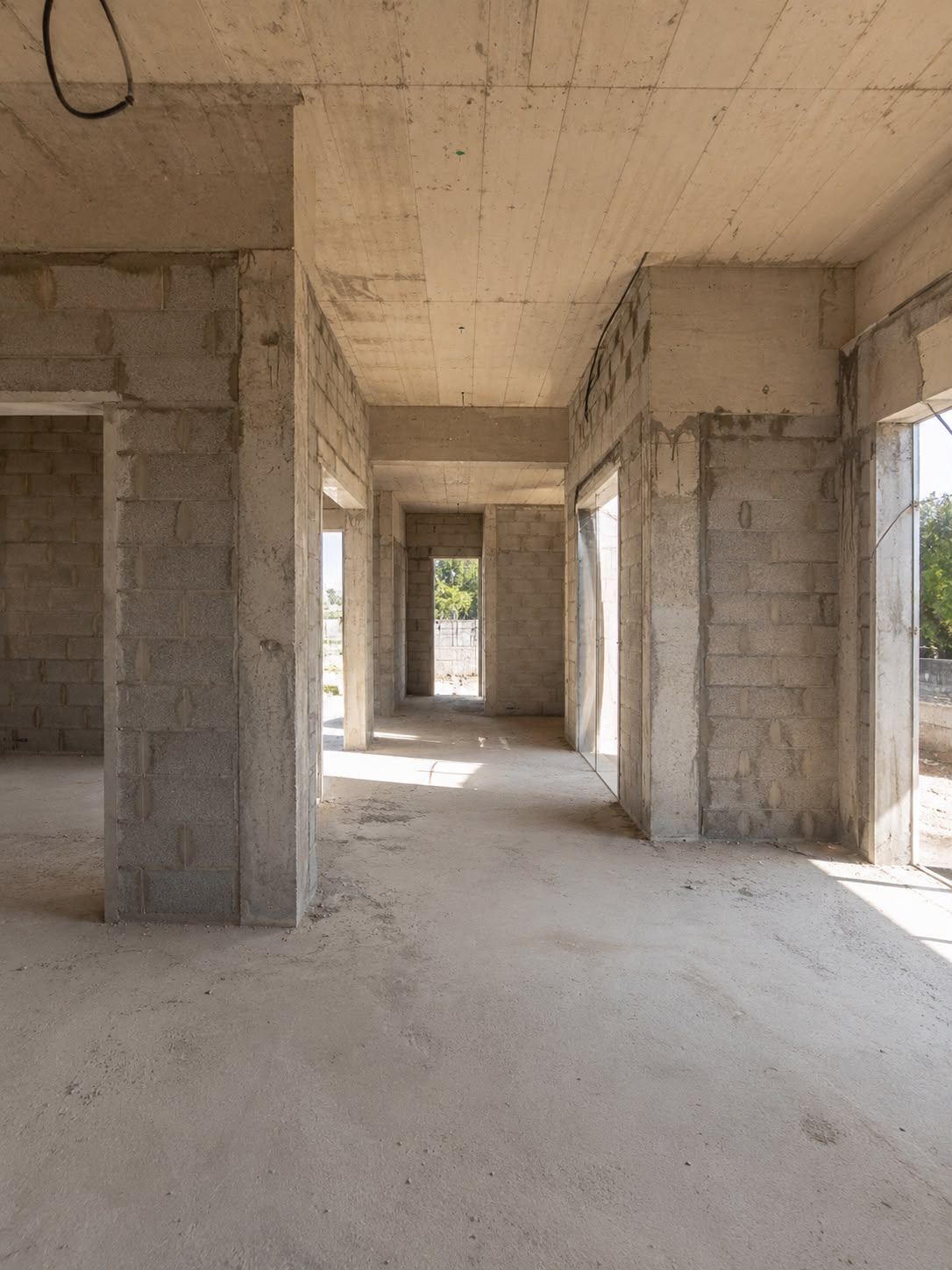 שלד בטון חשוף של בית בבנייה, עם קירות בלוקים ותקרה יצוקה