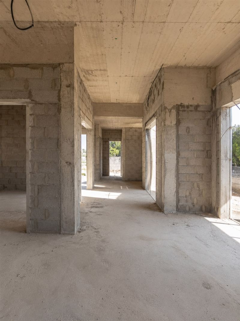 שלד בטון חשוף של בית בבנייה, עם קירות בלוקים ותקרה יצוקה